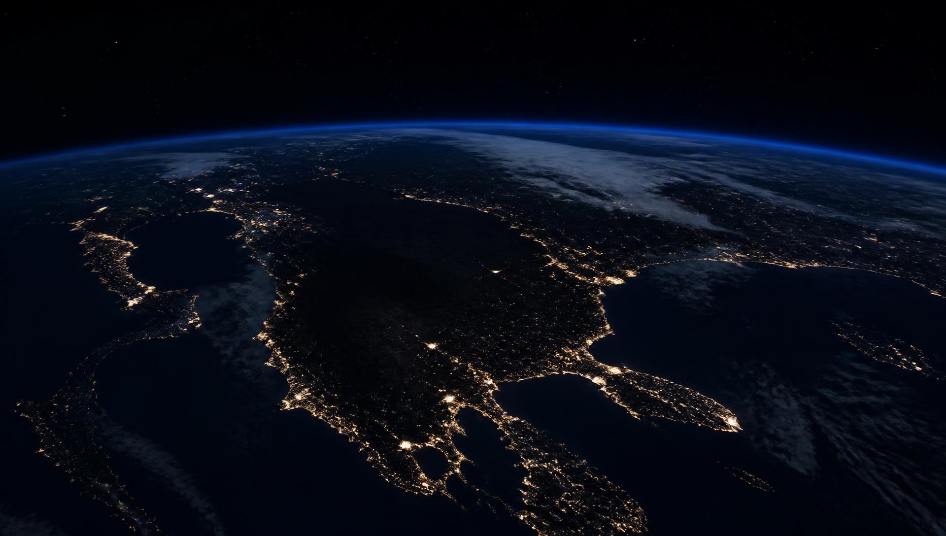 Orbital night view showing lit coastlines against unlit continental interiors